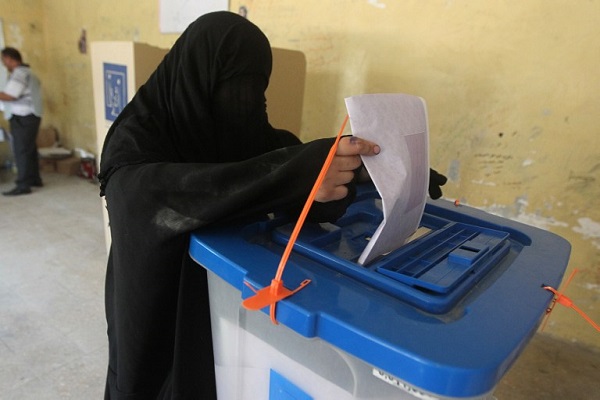 سيدة عراقية منقبة تضع ورقة الاقتراع في صندوق الانتخاب - أ.ف.ب