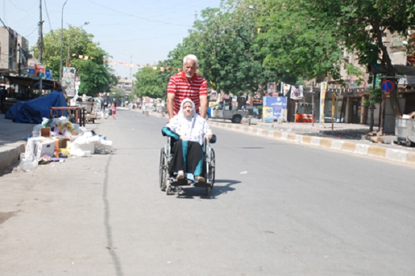 رجل برفقة سيدة مسنة متجهان إلى صندوق الاقتراع - وكالة الأنباء العراقية 