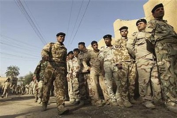 عسكريون عراقيون امام احد مراكز الاقتراع بانتظار التصويت