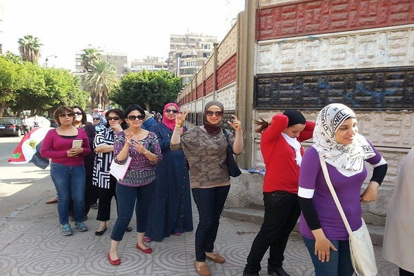 نساء يشرن بعلامة السيسي اثناء انتظار التصويت