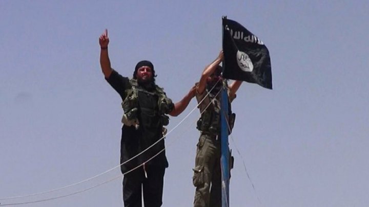 عنصران من تنظيم الدولة الاسلامية يرفعان علم الخلافة