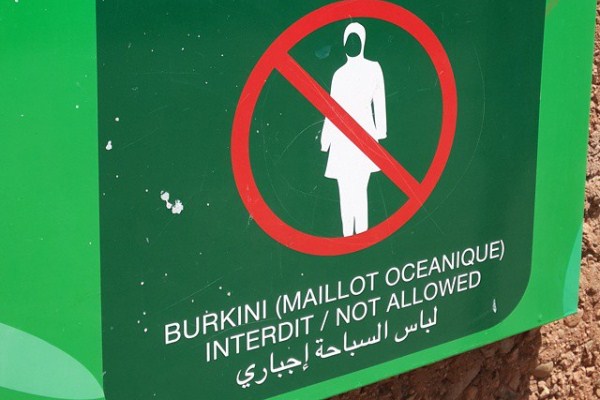 ملصق مكتوب بالعربية والفرنسية والانكليزية يؤكد منع البوركيني