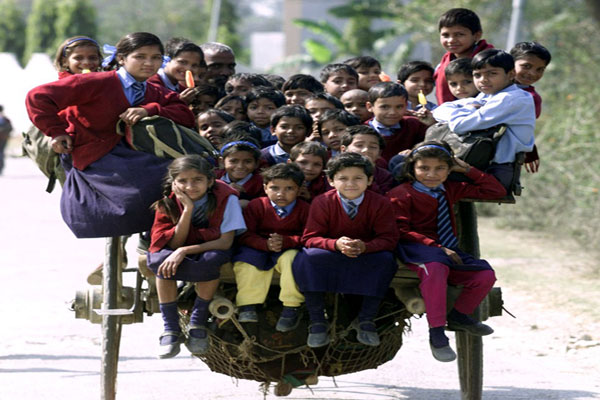 يجلس 35 طفلًا في عربة يجرها حصان واحد للوصول إلى المدرسة في ضواحي نيودلهي في الهند.