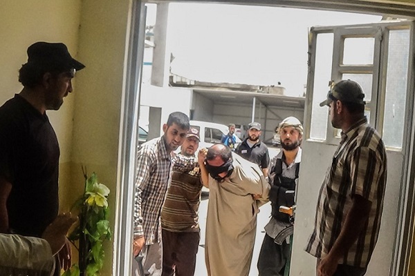 عناصر الشرطة الاسلامية يقتادون معتقلا في الموصل