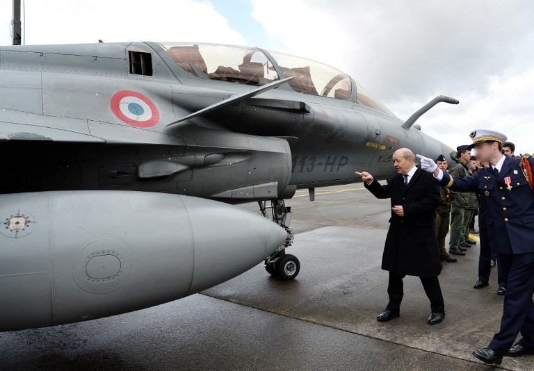 وزير الدفاع الفرنسي جان-ايف لودريان إلى جانب طائرات رافال