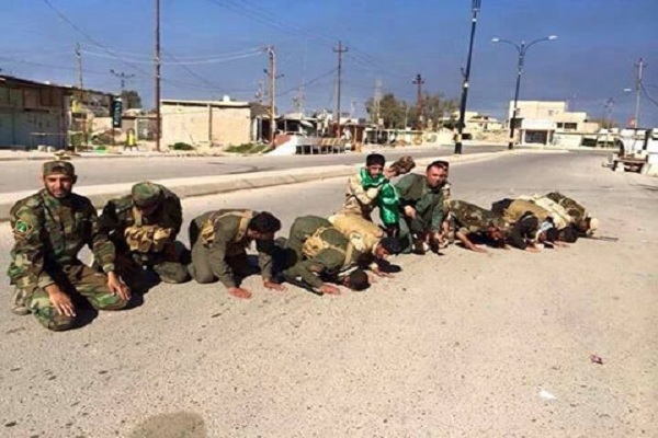 مقاتلون عراقيون يقبلون تراب تكريت لدى الدخول اليها