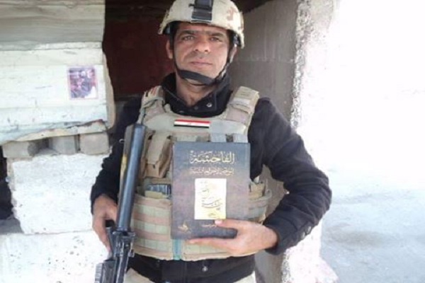 مسلح عراقي يحمل كتاب الفاحشة