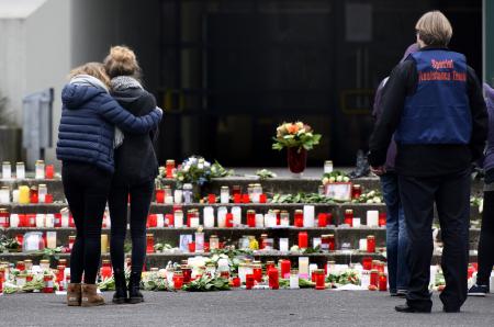  مواطنون ألمان يقفون أمام ورود وشموع على ضحايا تحطم الطائرة الألمانية-أ.ف.ب