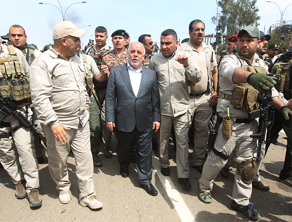 العبادي يتوسط جنودا عراقيين بعد تحرير مدينة تكريت من قبضة داعش- أ.ف.ب
