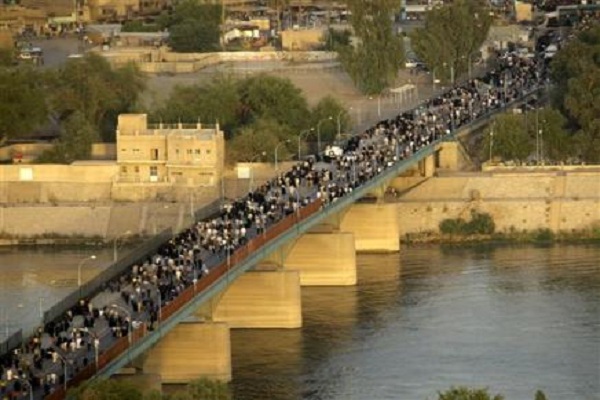 زائرو الكاظمية يعبرون اليها عبر جسر الائمة من جهة الاعظمية