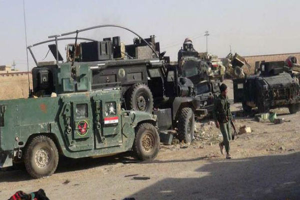  مقاتل في صفوف داعش يسير بين مركبات للجيش العراقي في الرماديبعد السيطرة عليها