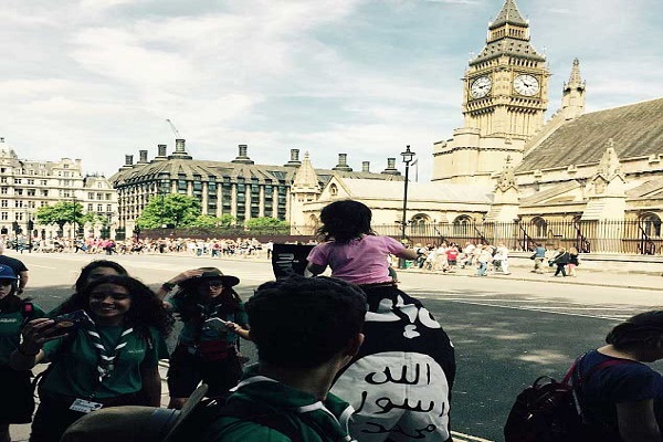 الرجل وعلى كتفيه طفلة يلوحان بأعلام داعش