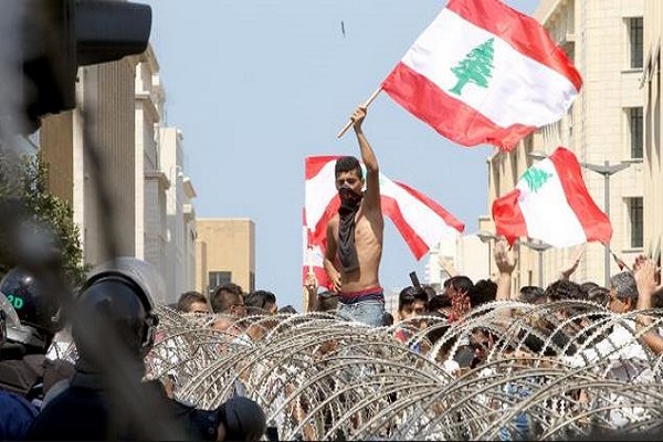 متظاهر يرفع علم لبنان في التظاهرات