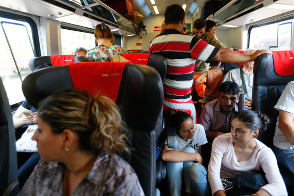 مهاجرون يجلسون على أرضية القطار في طريقه من بودابست إلى فيينا