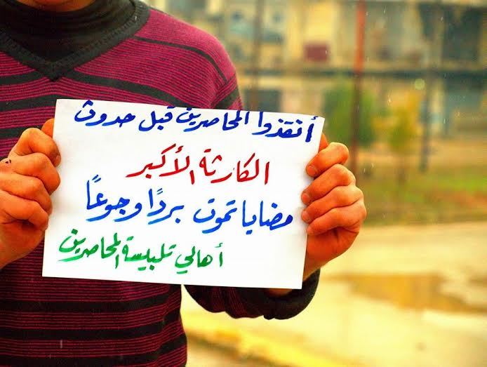 سوري يرفع شعارات تنادي برفع الحصار عن مضايا 