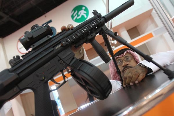 اماراتي يتفحص احدى البنادق في معرض للسلاح