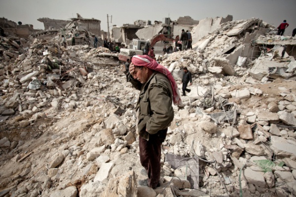 سوري يقف وسط الدمار