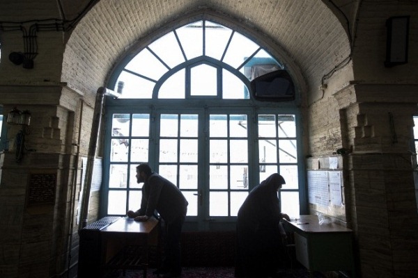 عاملان إيرانيان في أحد مراكز الاقتراع