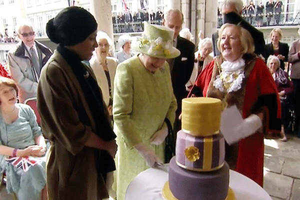 الملكة أثناء قطع قالب الحلوى الخاص بميلادها