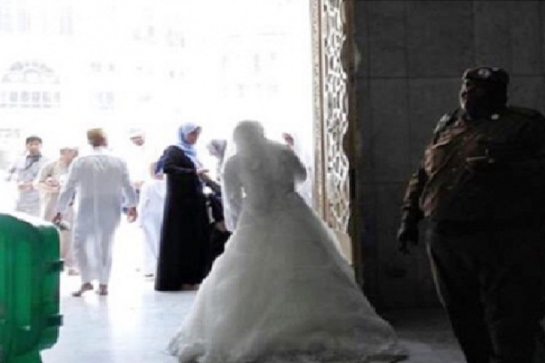 فتاة ترتدي فستان زفاف تحاول الدخول للحرم المكي