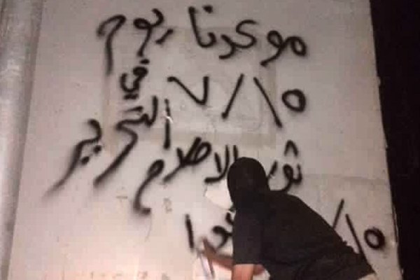 شاب يكتب شعارات تدعو للمشاركة في مليونية الاصلاح الجمعة المقبل