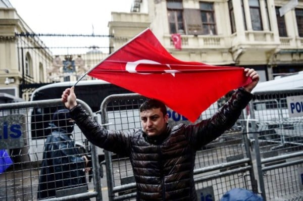 مواطن يرفع العلم التركي في أمستردام عقب مواجهات بين أتراك والشرطة