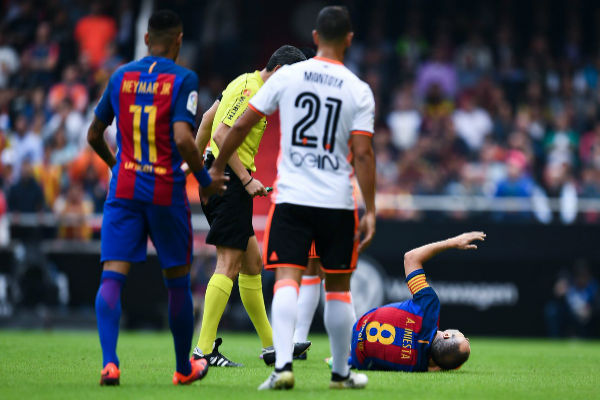 إنييستا متألماً من إصابته في لقاء برشلونة وفالنسيا