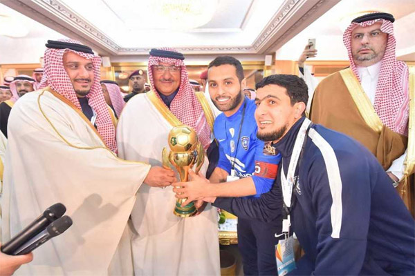 ولي العهد السعودي يسلم كأس البطولة لقائد الفريق ياسر القحطاني ورئيس النادي الأمير نواف بن سعد