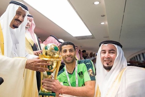 العاهل السعودي يسلم الكأس لتيسير الجاسم قائد فريق الأهلي