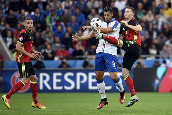 مدافع بلجيكا فيرمايلين يحاول قطع الكرة من اللاعب الإيطالي