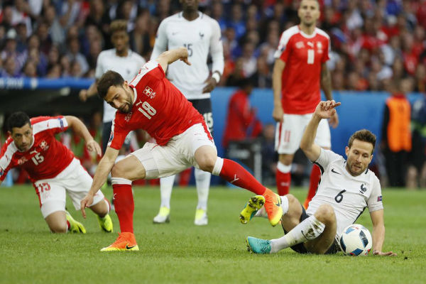 يوهان كاباي يحاول استخلاص الكرة من أحد لاعبي سويسرا