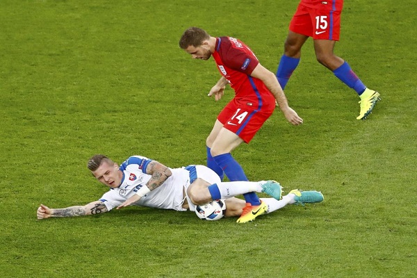 الانكليزي جوردان هيندرسون يحاول الحصول على الكرة من السلوفاكي يوراي كوسكا