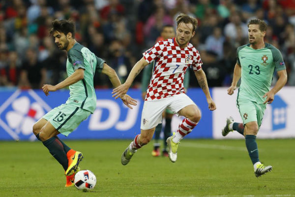ينجم وسط كرواتيا راكيتيتش يحاول التخلص من لاعبي المنتخب البرتغال