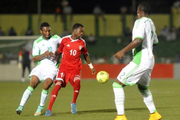لاعب المنتخب السوداني، مهند الطاهر، أمام لاعبيين من المنتخب النيجيري في تصفيات كأس أمم أفريقيا