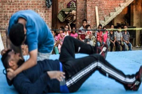 أطفال يتابعون تمرين مصارعة خارج منزل أشرف محروس في الإسماعيلية