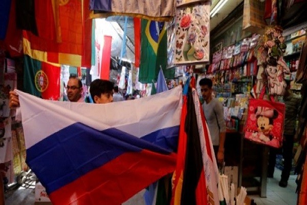 العلم الروسي بين مجموعة من أعلام المنتخبات المشاركة في كأس العالم في كرة القدم 2018، كما يبدو خارج متجر في دمشق القديمة
