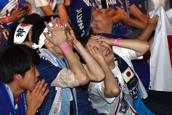 المشجعون اليابانيون بتابعون مباراة منتخب بلادهم ضد بولندا في كأس العالم على شاشة عملاقة