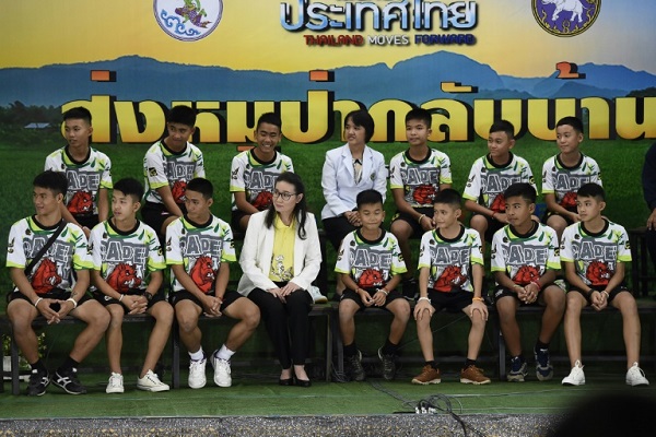 الفتيان التايلانديون الاثنا عشر ومدربهم لكرة القدم خلال مؤتمر صحافي بعد خروجهم من مستشفى شيانغ راي