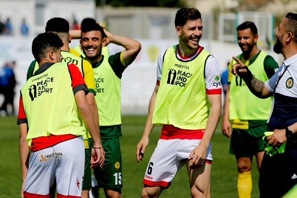 لاعبون من القبارصة الأتراك واليونانيين على هامش مباراة ودية في كرة القدم في 19 آذار/مارس 2019.
