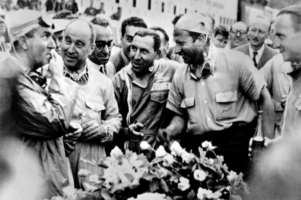 السائق الأرجنتي خوان مانويل فانجيو (الثاني من اليسار) يتحدث الى الإيطالي جيوسيبي فارينا على حلبة سبا فرانكورشان في 18 يونيو 1950.