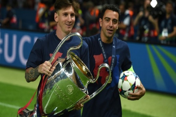 ليونيل ميسي (يسار) وتشافي هرنانديز يحتفلان مع الكأس بعد تتويج فريقهما برشلونة بلقب دوري أبطال أوروبا عام 2015 