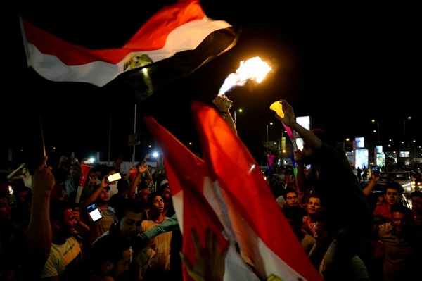 مصريون يحتفلون في شوارع القاهرة بفوز منتخب بلادهم على زيمبابوي في بطولة كأس الأمم الإفريقية في كرة القدم، في 21 حزيران/يونيو 2019.