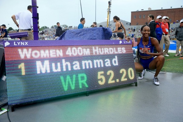 العداءة الاميركية دليلة محمد تلتقط صورة إلى جانب اللوحة الالكترونية التي تشير إلى رقمها القياسي العالمي في سباق 400 م حواجز والذي سجلته في بطولة الولايات المتحدة