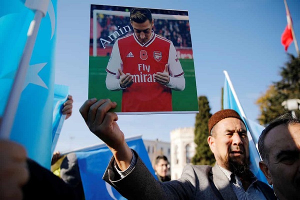  متظاهر يحمل صورة لمسعود أوزيل الذي انتقد الصين في طريقة تعاملها مع الأقليات المسلمة