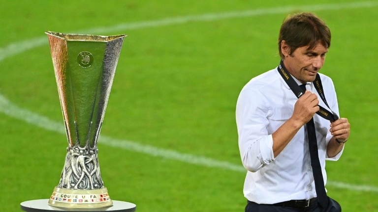 المدرب الإيطالي أنتونيو كونتي يمر قرب كأس مسابقة الدوري الأوروبي (يوروبا ليغ) بعد خسارة فريقه إنتر ميلان في المباراة النهائية أمام إشبيلية الإسباني 2-3، في 21 آب/أغسطس 2020.