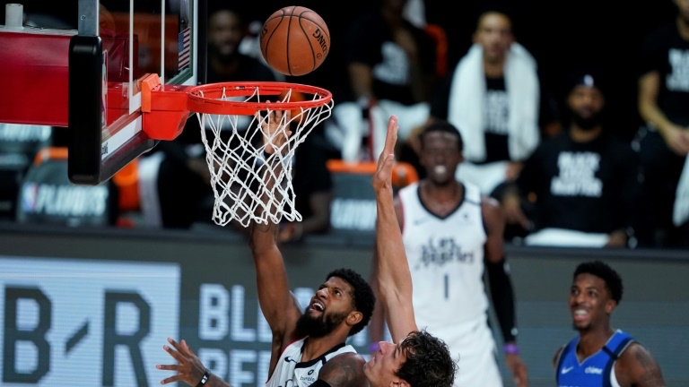 نجم لوس انجليس كليبرز بول جورج (رقم 13) في محاولة أمام العملاق الصربي في دالاس مافريكس بوبان ماريانوفيتش (رقم 51) خلال المباراة الخامسة بين الفريقين