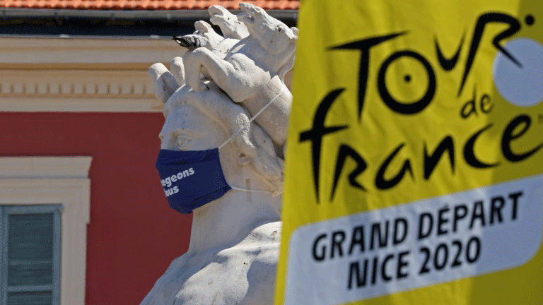 شعار طواف فرنسا للدراجات الهوائية الى جانب ثمثال يرتدي كمامة في مدينة نيس نقطة الانطلاق في 26 آب/أغسطس 2020