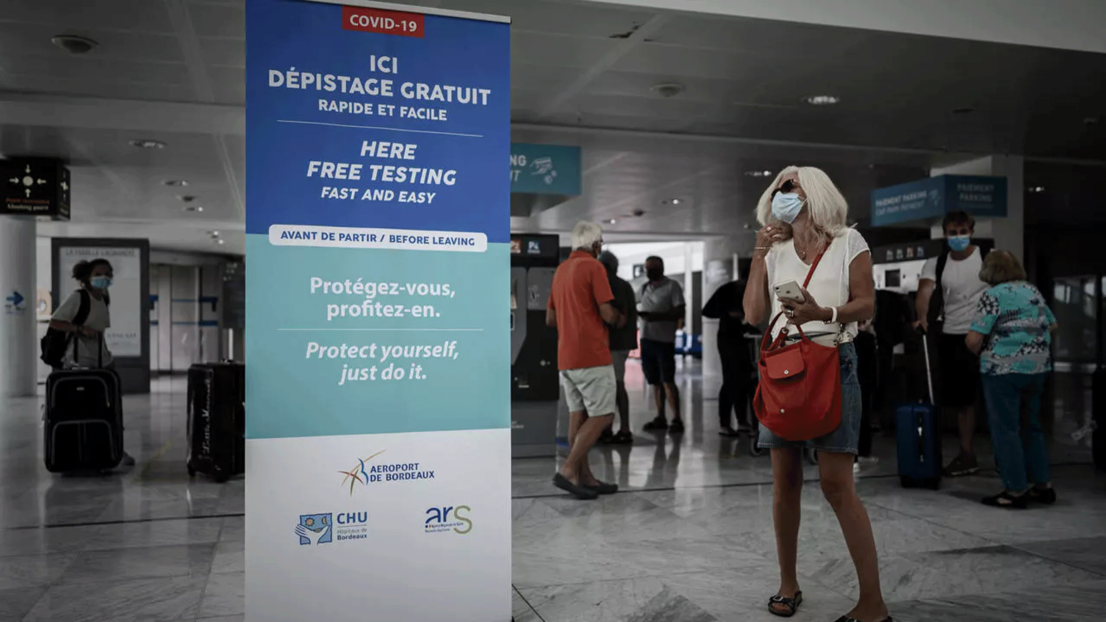 مسافرة ترتدي كمامة في مطار بوردو-مارينياك في فرنسا، في 23 يوليو 2020