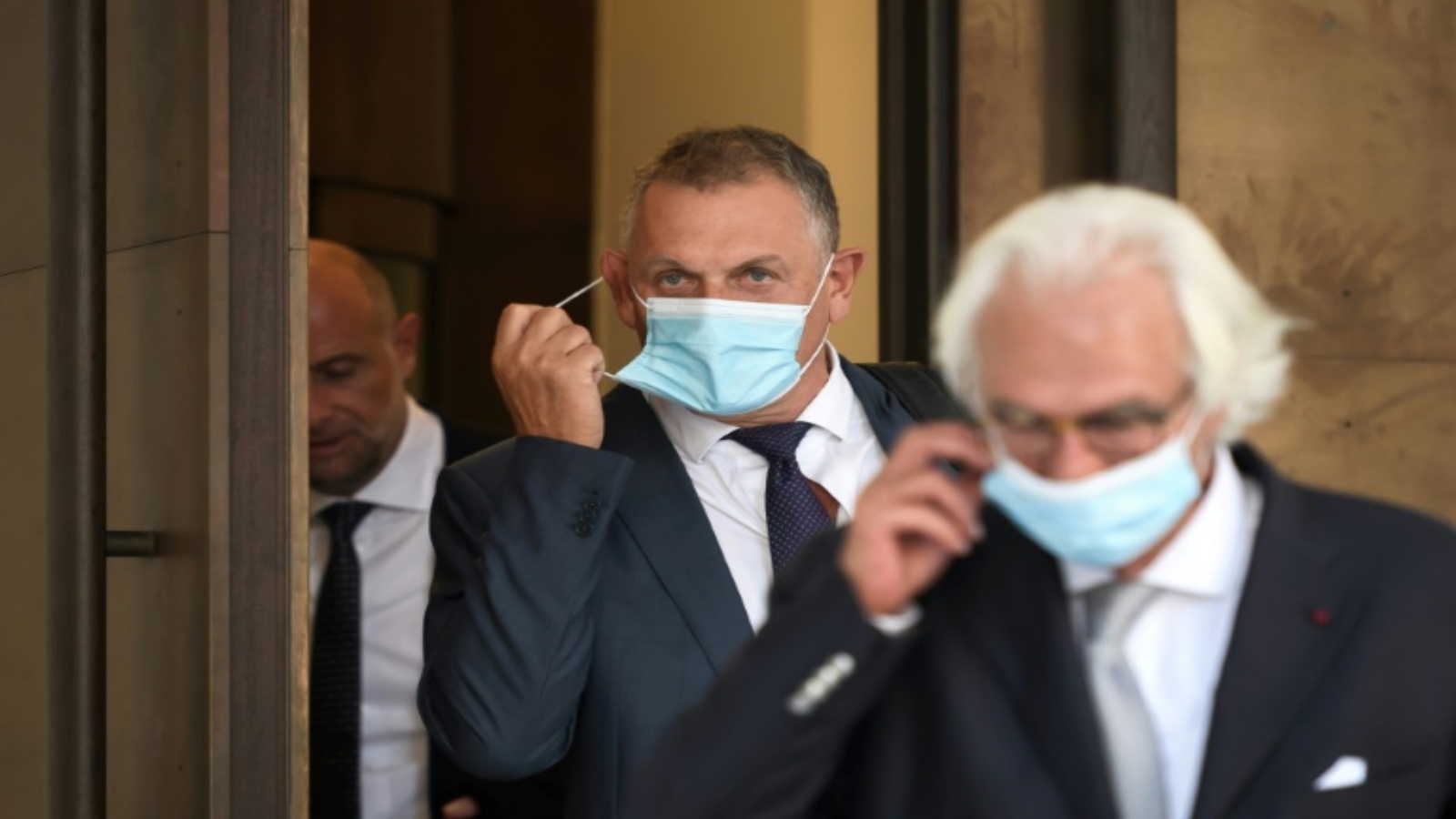 الامين العام السابق للفيفا الفرنسي جيروم فالك (وسط) لحظة خروجه من محكمة بيلينزون خلف المحامي السويسري مارك بونان في 14 أيلول/سبتمبر 2020.