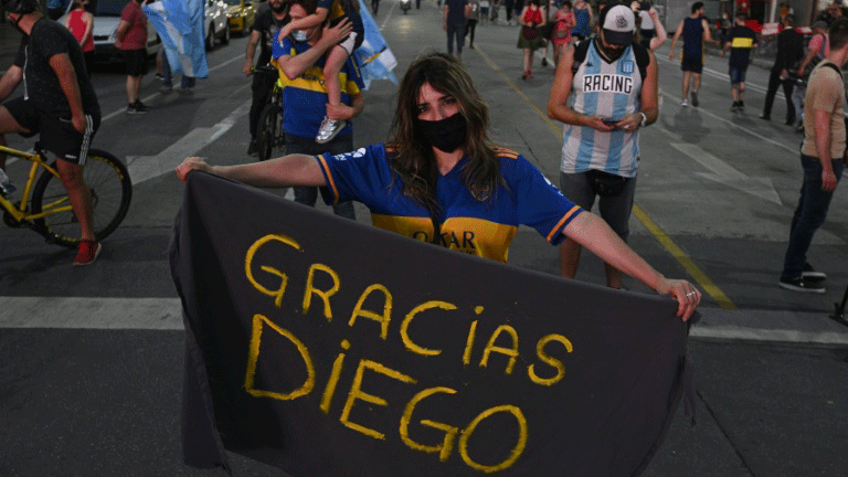 معجبة باسطورة كرة القدم الأرجنتينية دييغو مارادونا تحمل لافتة كتب عليها بالإسبانية 